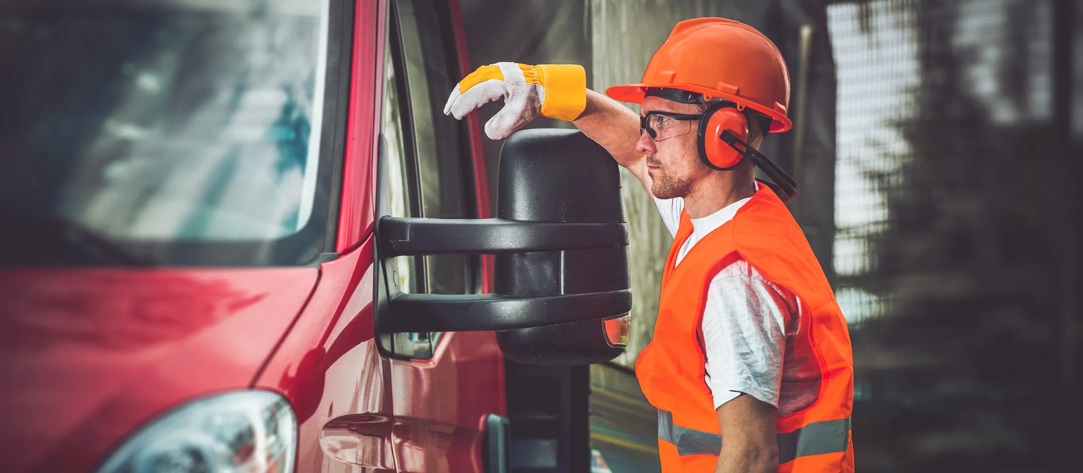 Worker inspecting a red truck cab