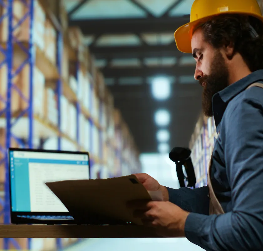 Worker using a laptop and scanner in a warehouse