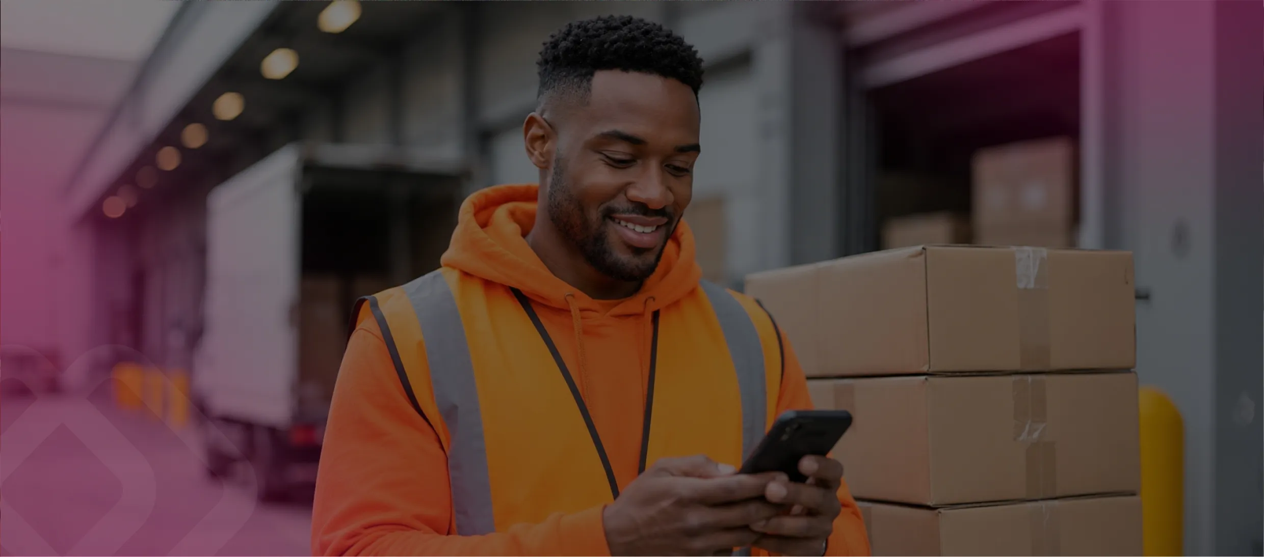 Smiling worker using a phone in a warehouse