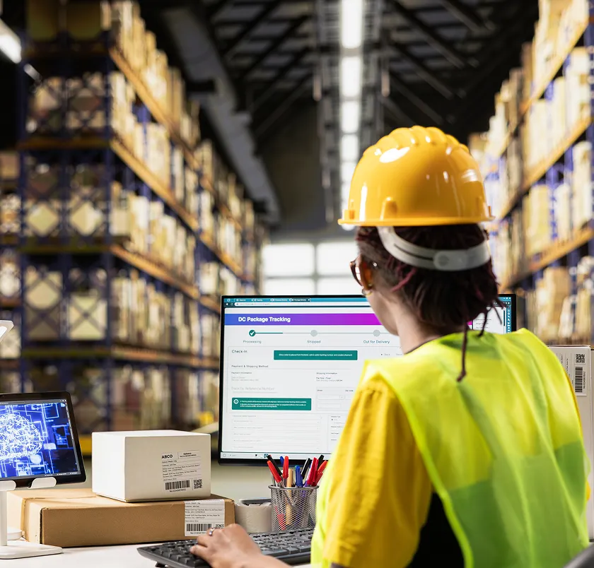 Warehouse worker using a package-tracking system on a computer