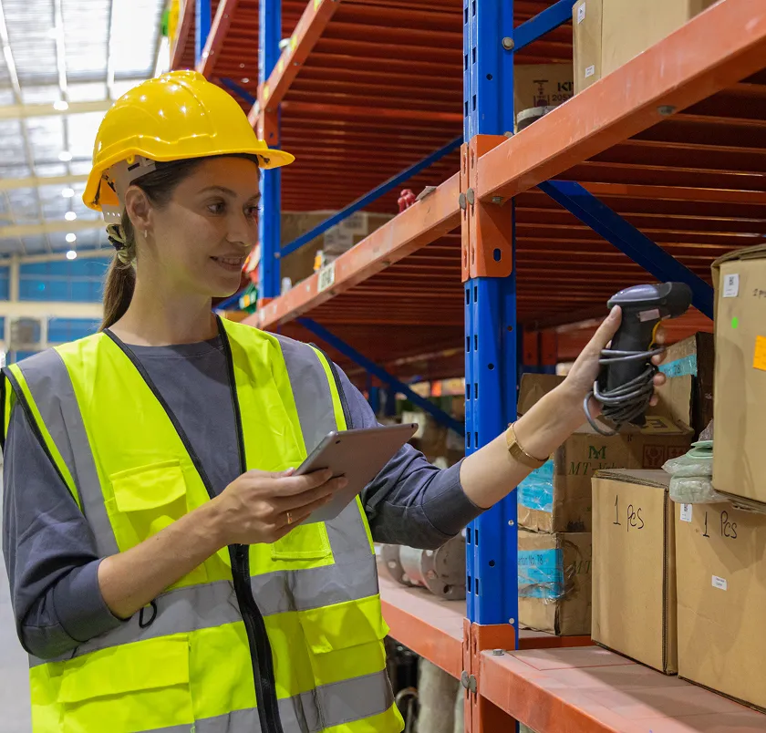 Warehouse worker in hi-vis using a scanner and tablet
