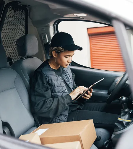 Delivery driver using a tablet in a van