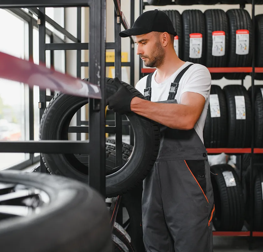 Worker handling a tyre in a tyre store
