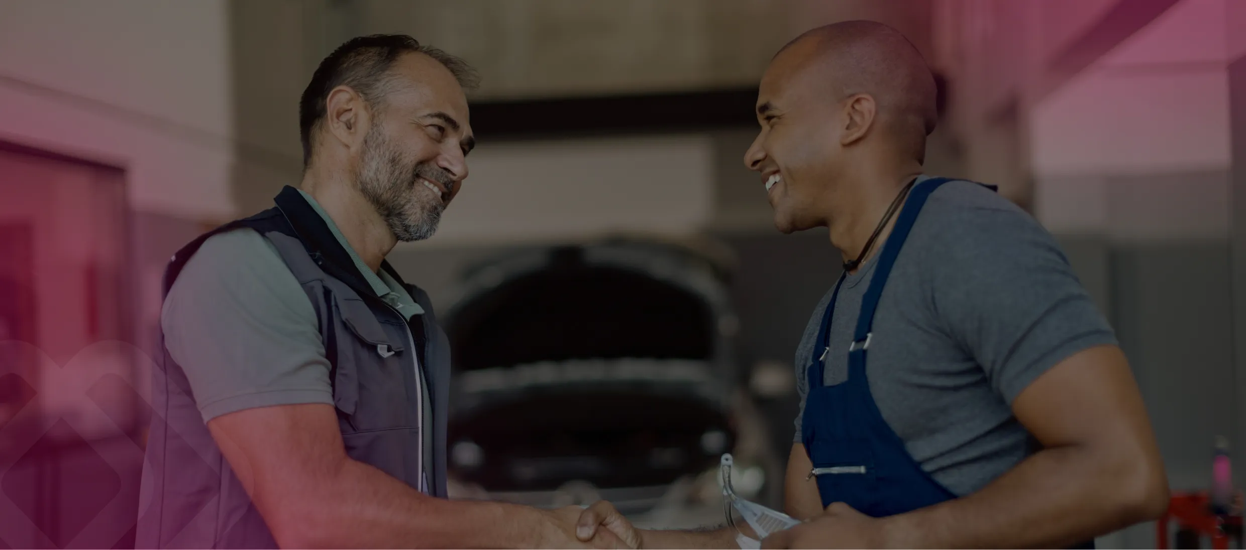 Two men shaking hands in a workshop