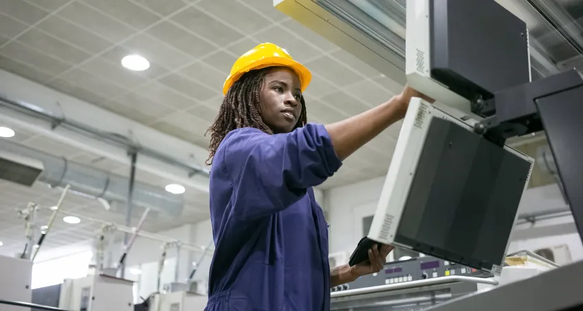 Worker in a hard hat inspecting overhead equipment
