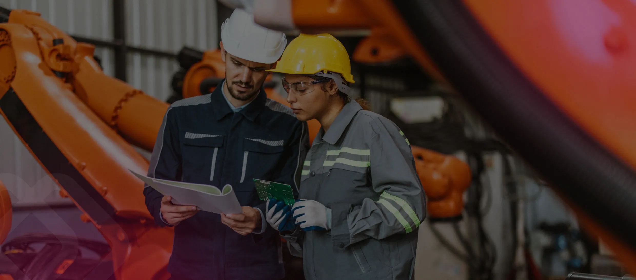Two workers in a factory with a tablet