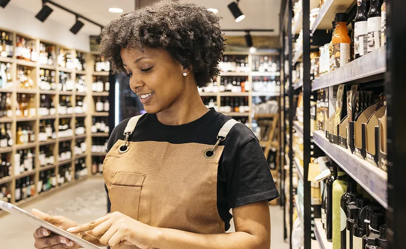 Shop worker using a tablet in a wine store