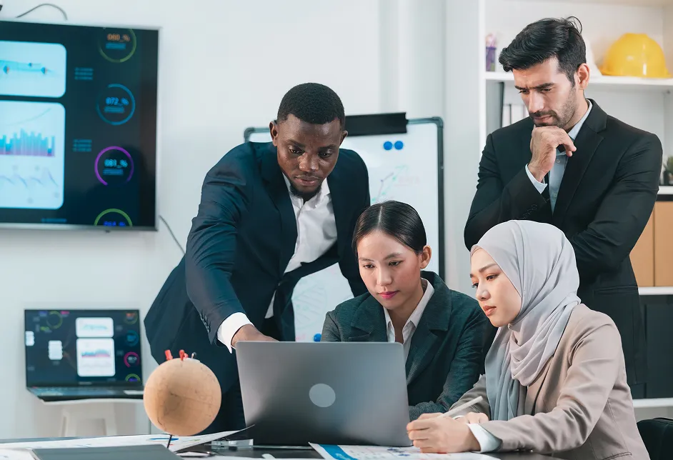 Team around a laptop with data dashboards