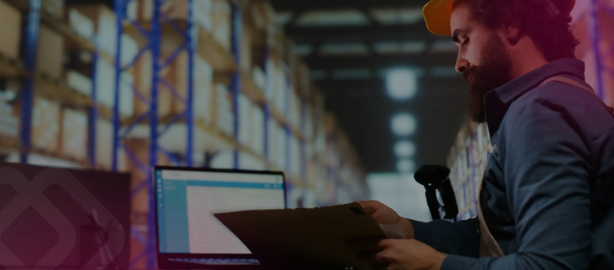 Man with a laptop among warehouse shelves