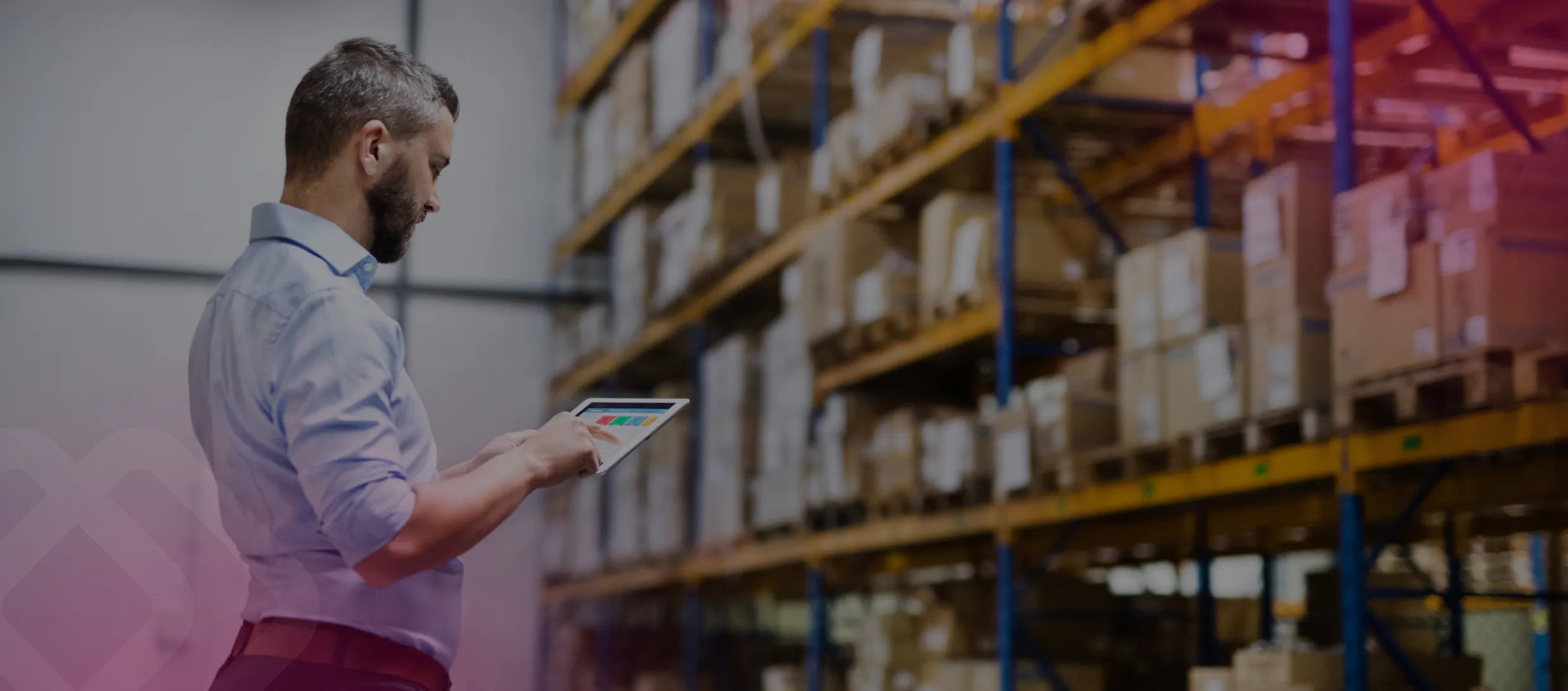 Warehouse worker using a tablet by shelves