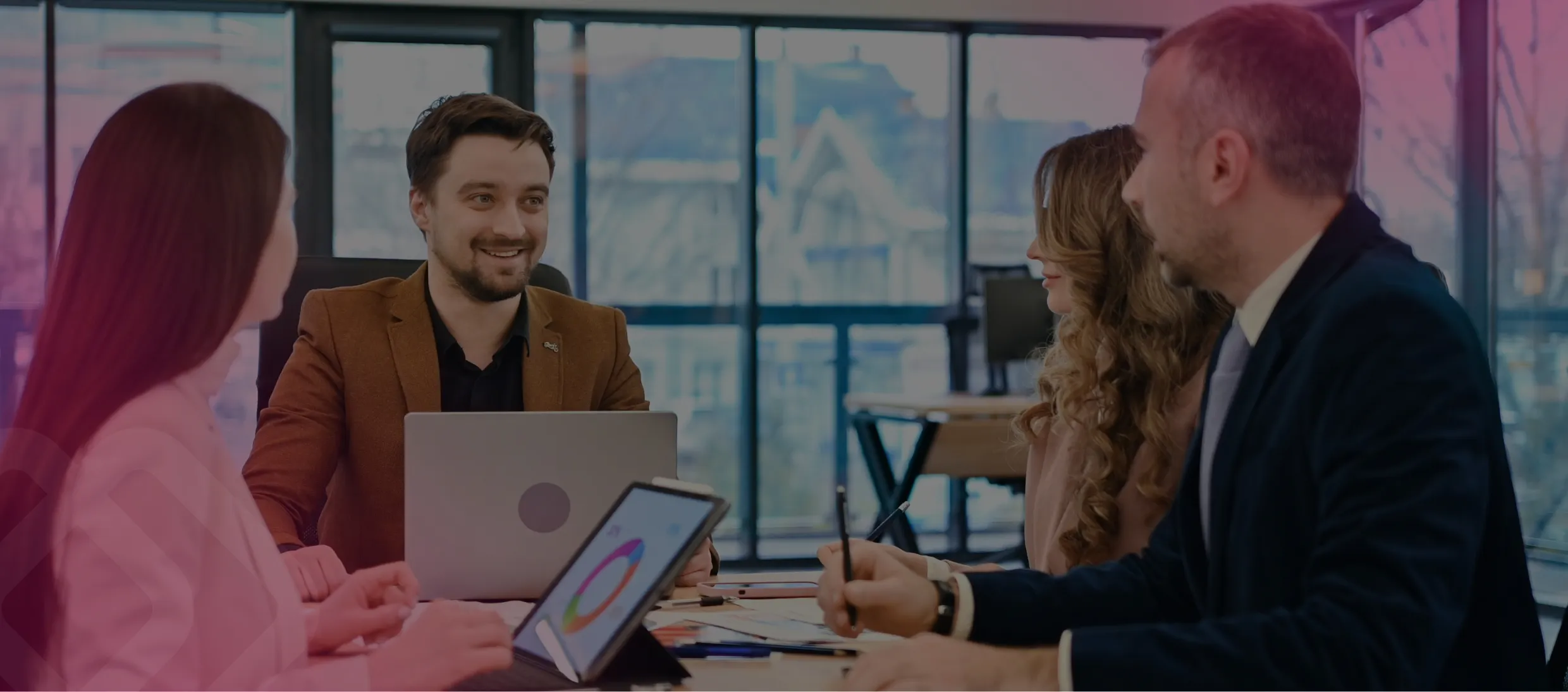 Colleagues meeting at a table with a laptop