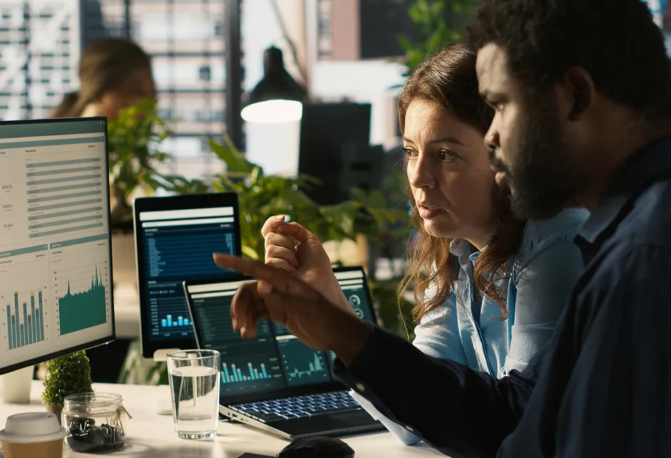 Colleagues reviewing data on screens