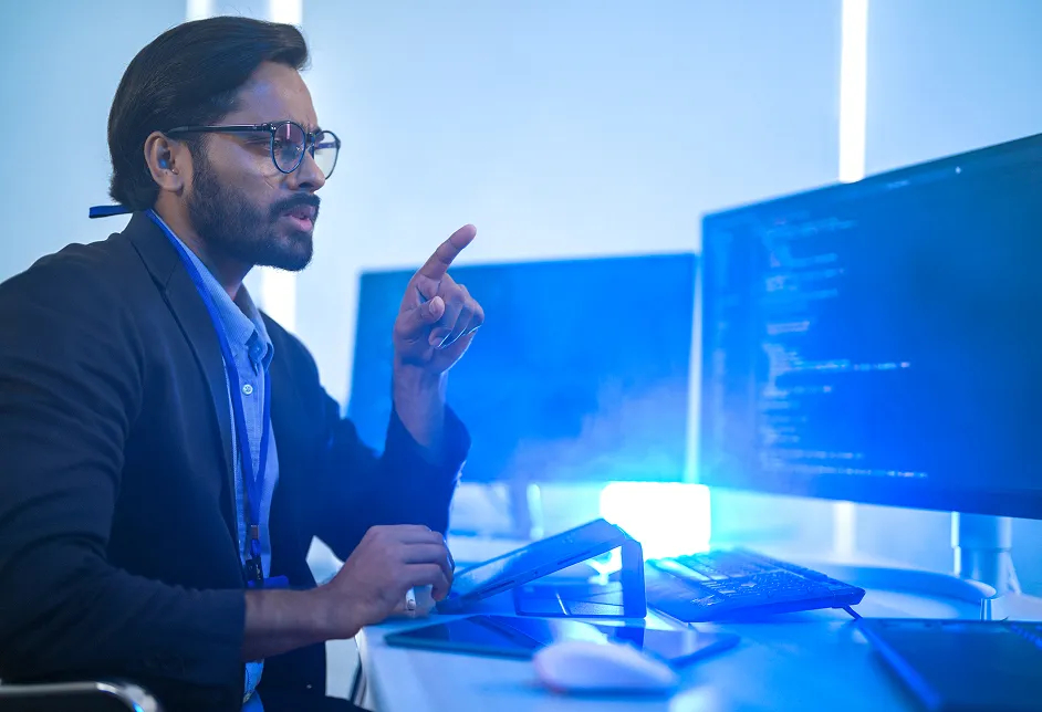 Man pointing at a screen showing code