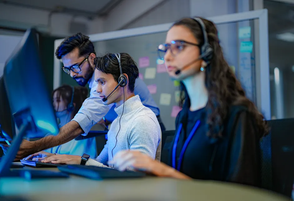 Call centre team wearing headsets at computers
