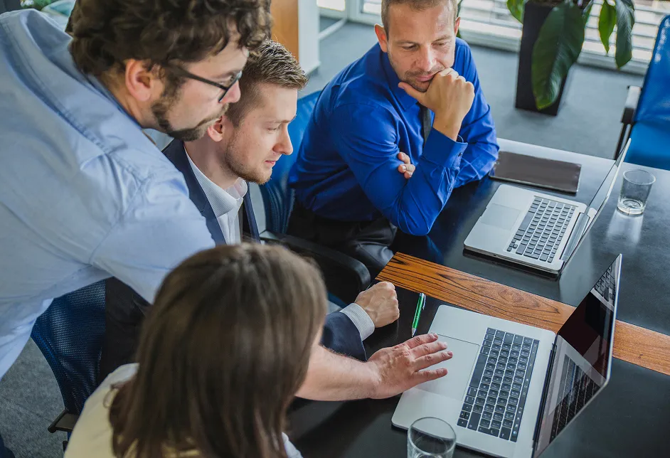 Group working around laptops in a meeting