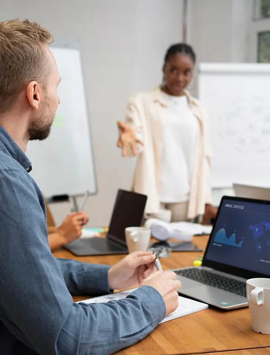 Man presenting to a colleague by a whiteboard