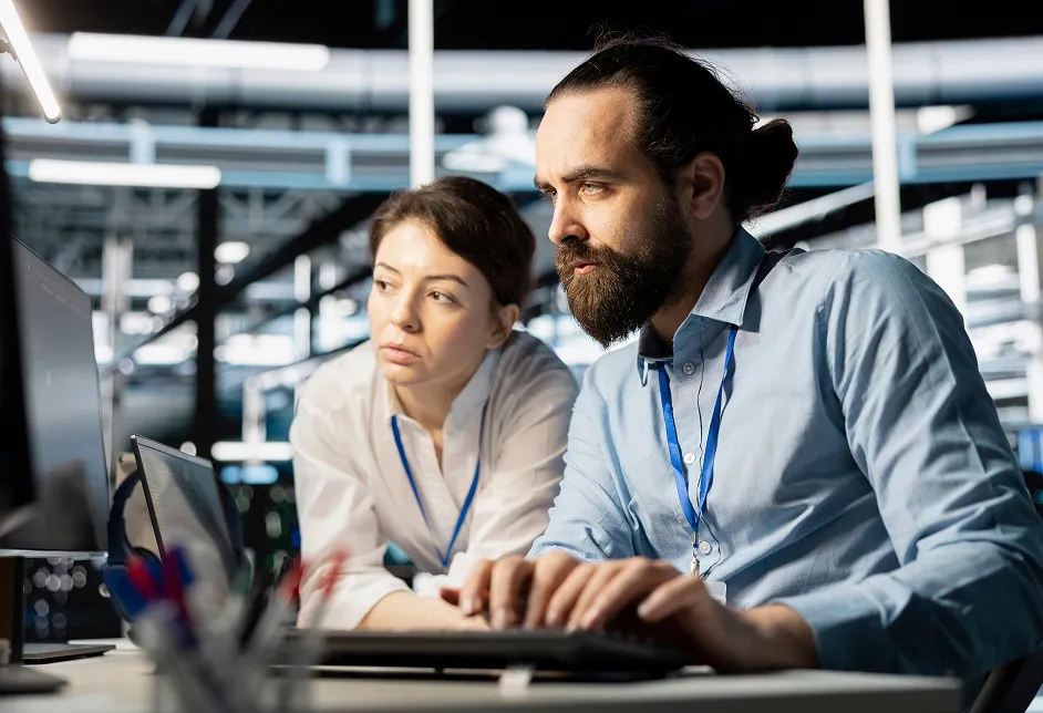 Two colleagues reviewing work at a screen