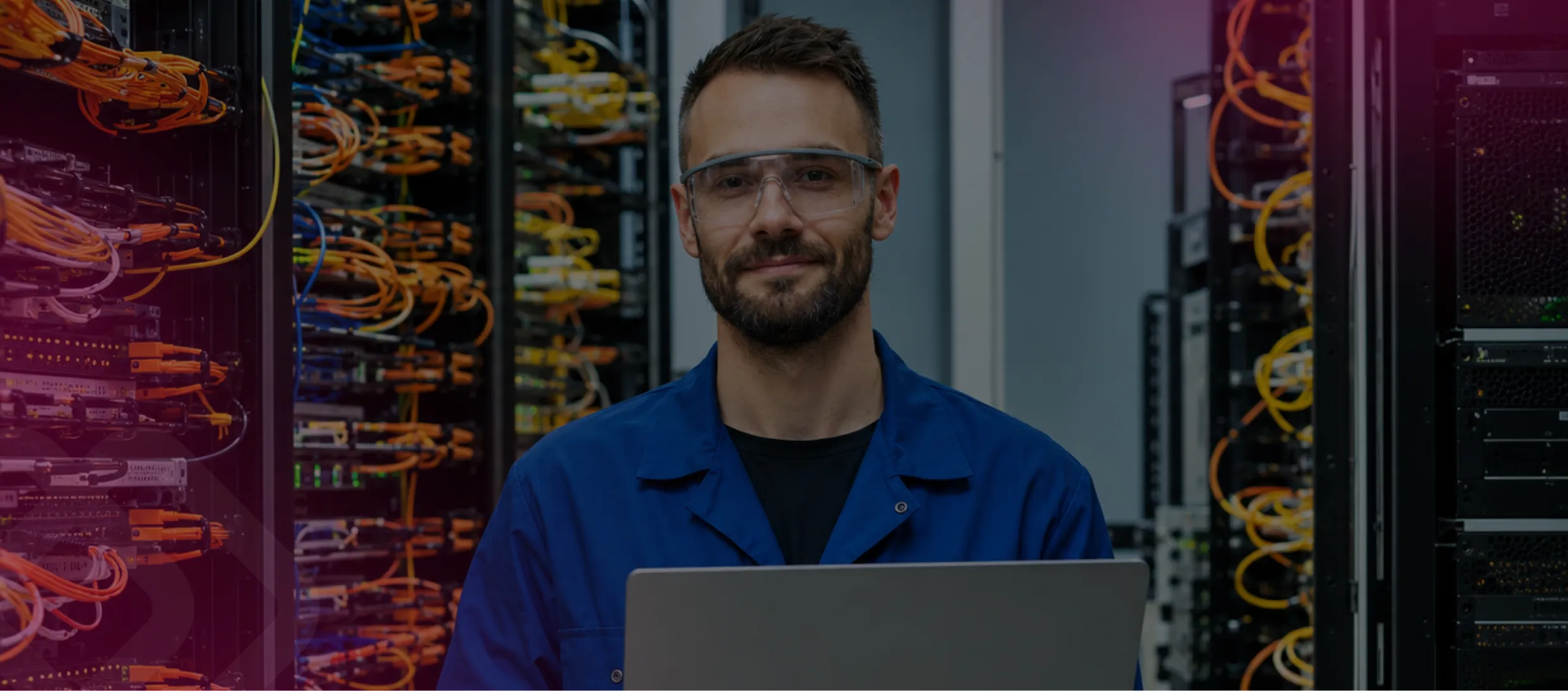 Man using a laptop in a server room