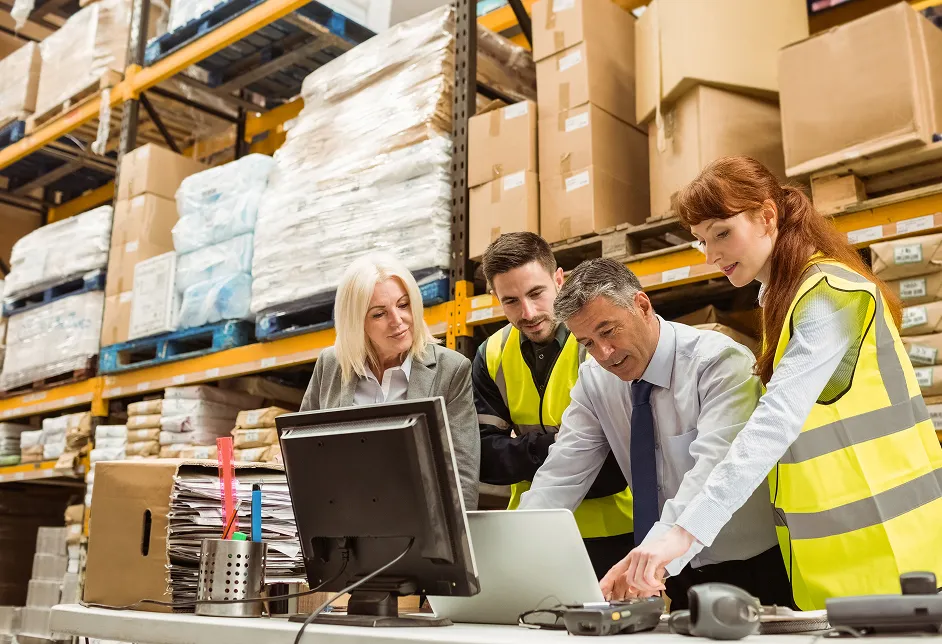 Warehouse staff reviewing a monitor