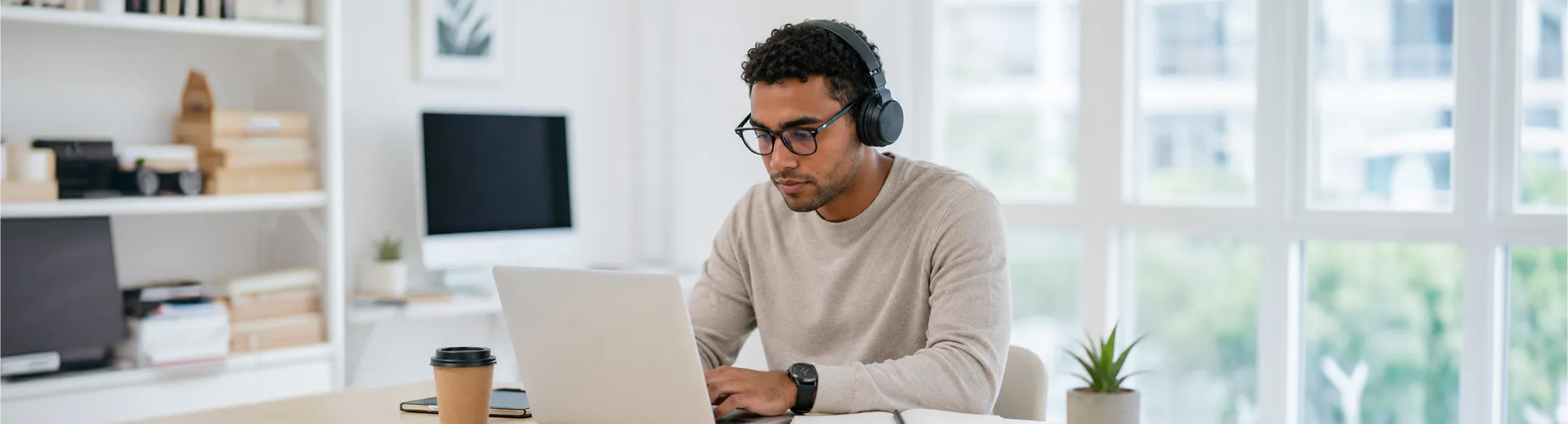 Man wearing a headset using a laptop