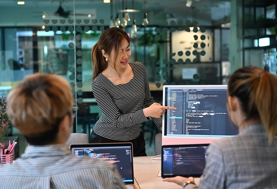 Two colleagues discussing work at a screen