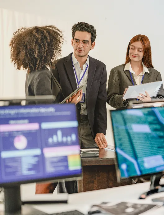 Colleagues reviewing dashboards on monitors