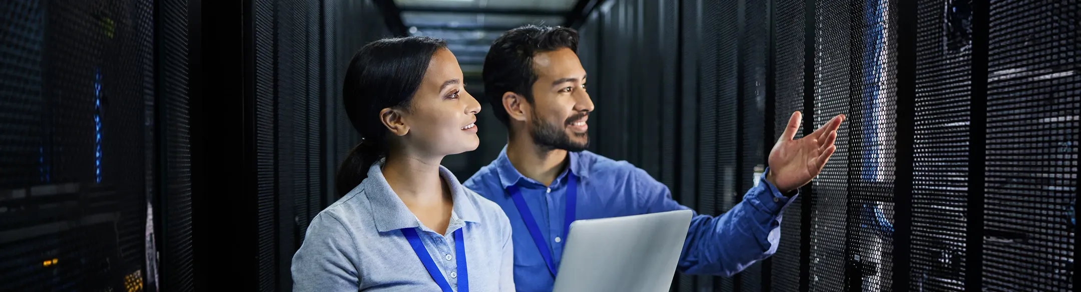 Two IT staff working in a server room