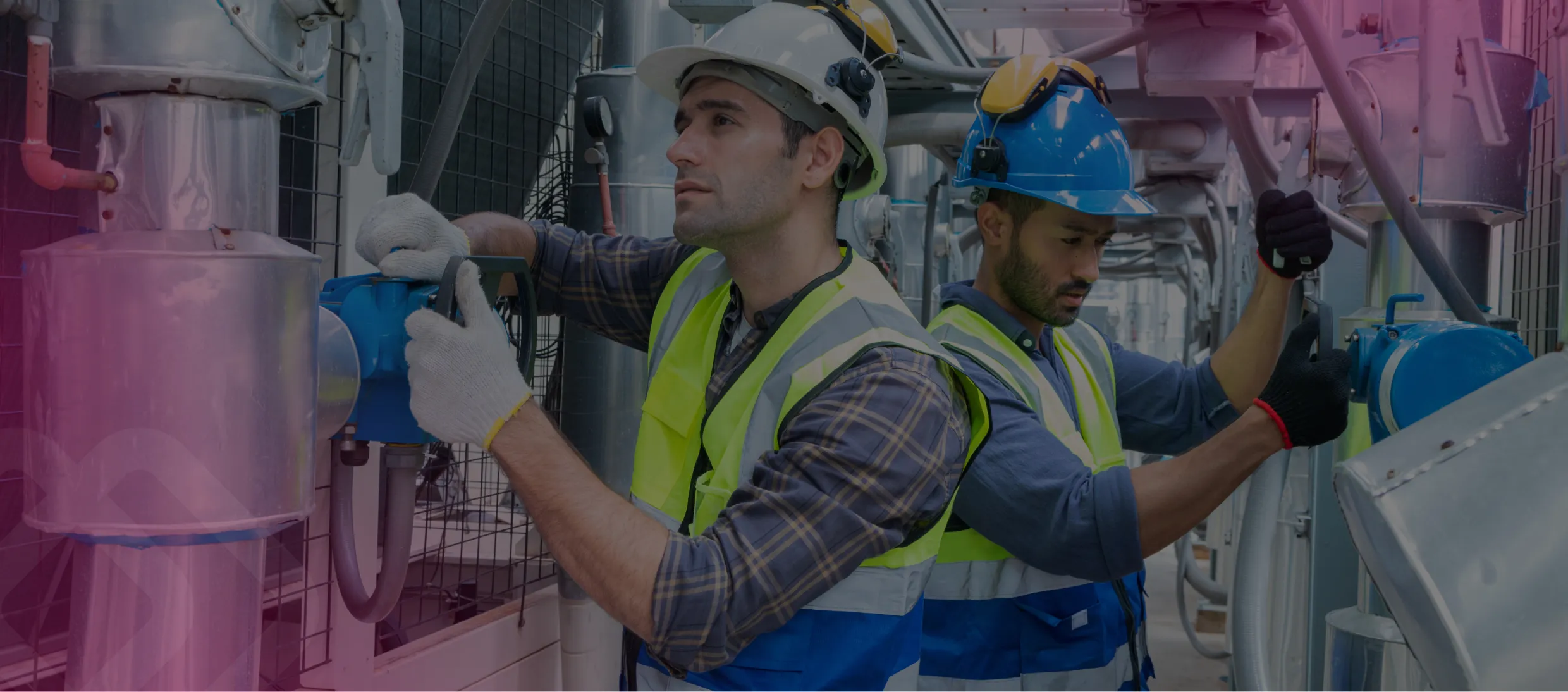 Two workers in hi-vis at industrial pipework