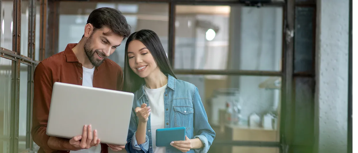 Two colleagues using a laptop in an office