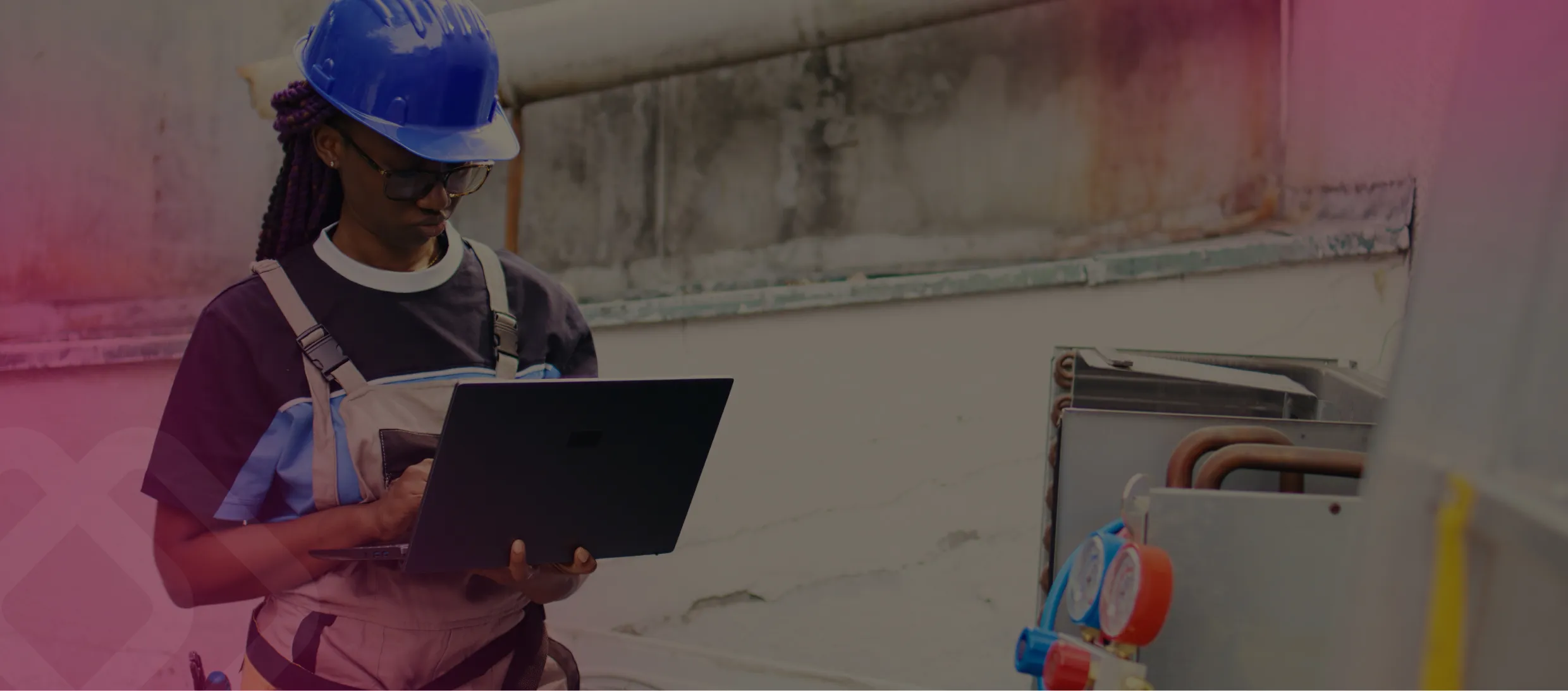 Worker using a laptop by refrigeration units