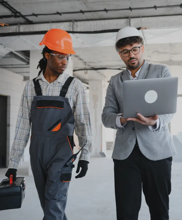 Two workers with a laptop on a site