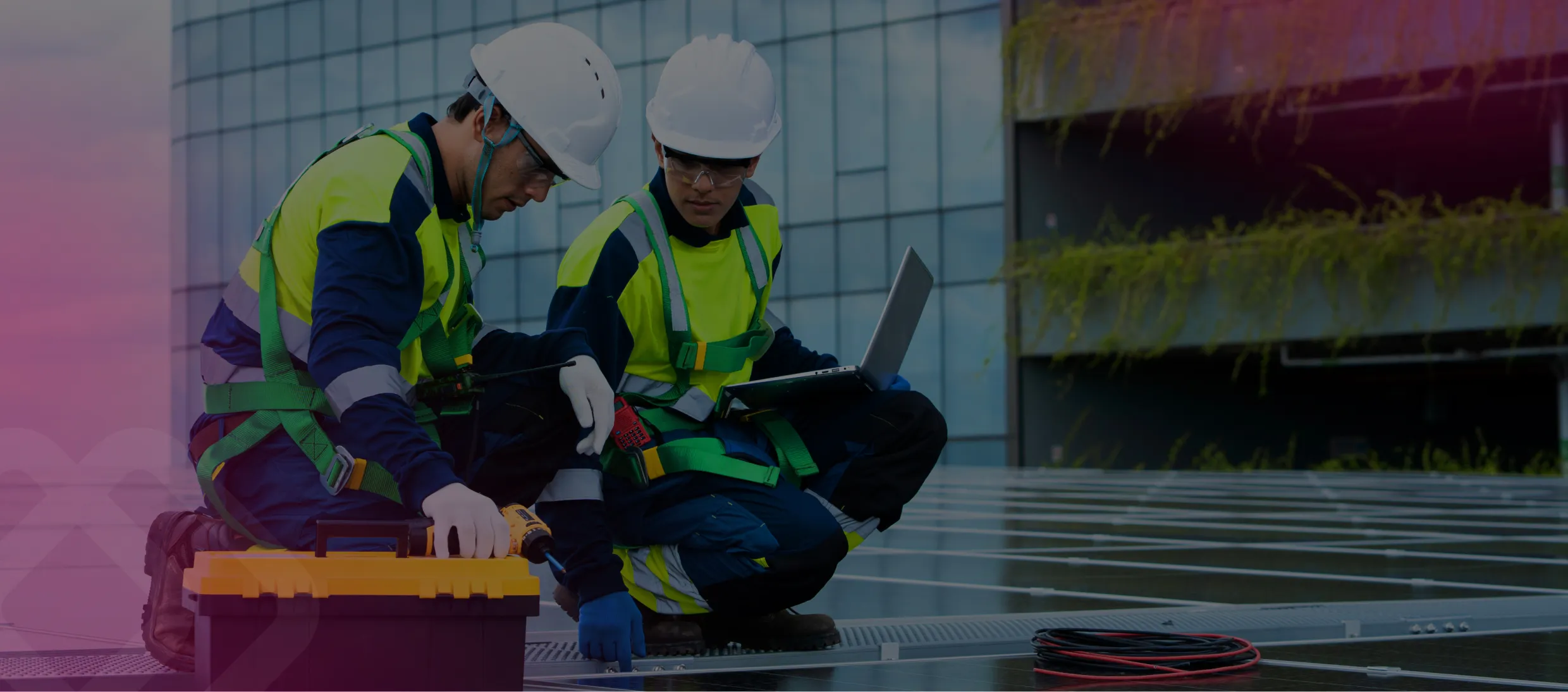 Two workers in hi-vis with a laptop