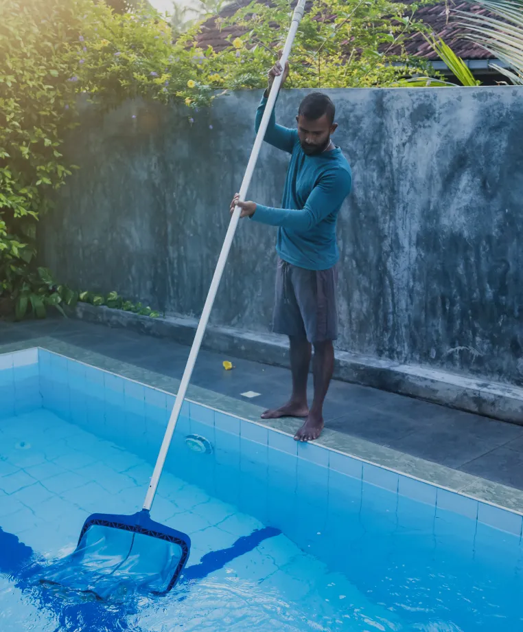 Person cleaning a pool with a net