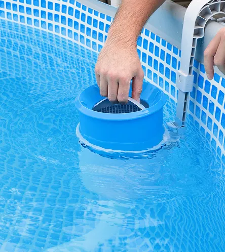 Hands cleaning a swimming pool skimmer