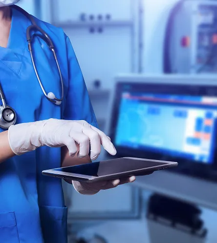 Doctor using a tablet beside a monitor