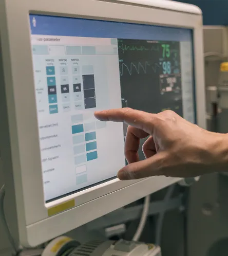 Hand using a touchscreen monitoring display