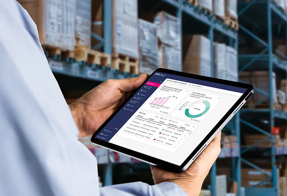 Hand holding a tablet showing a dashboard in a warehouse