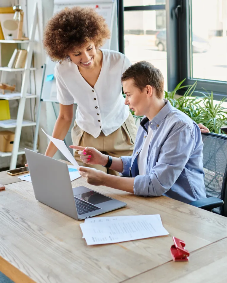 Two colleagues reviewing work at a desk