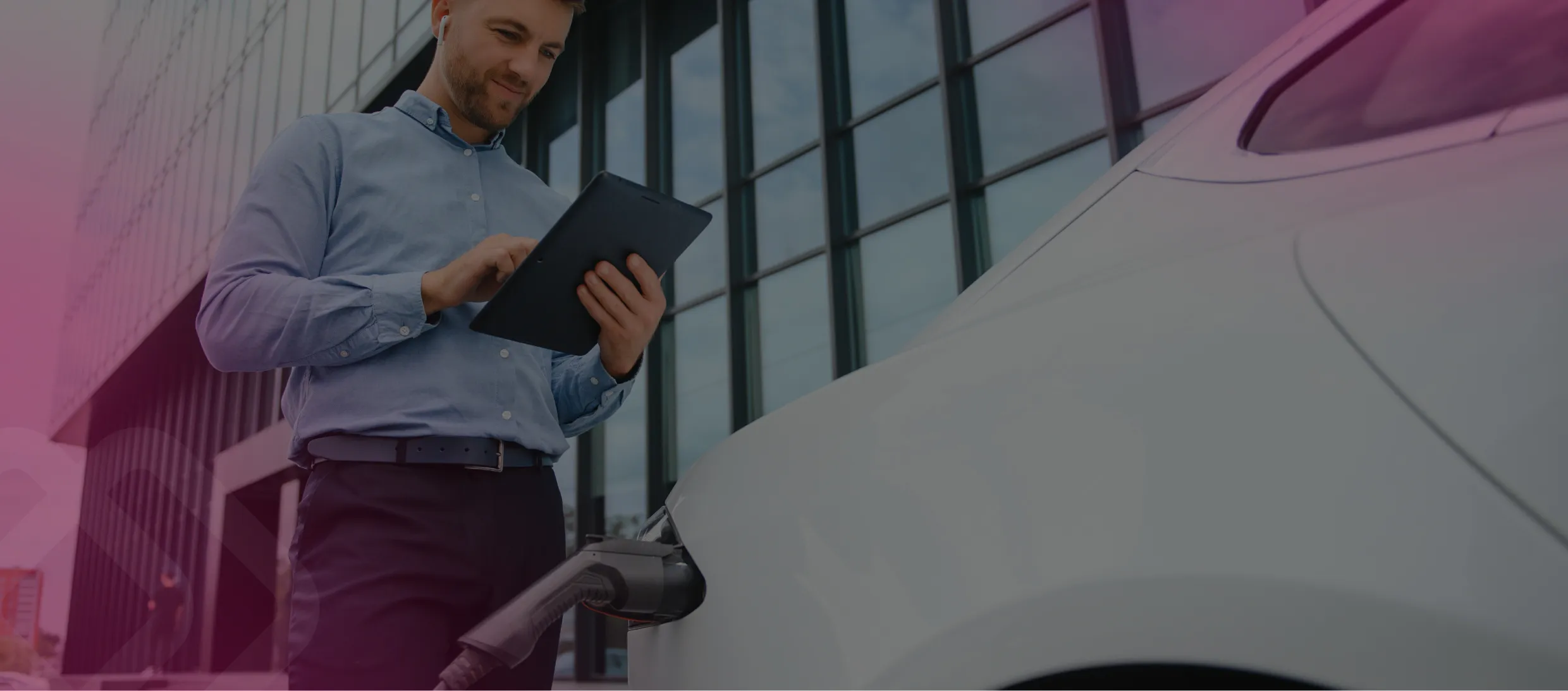 Worker using a tablet by a car