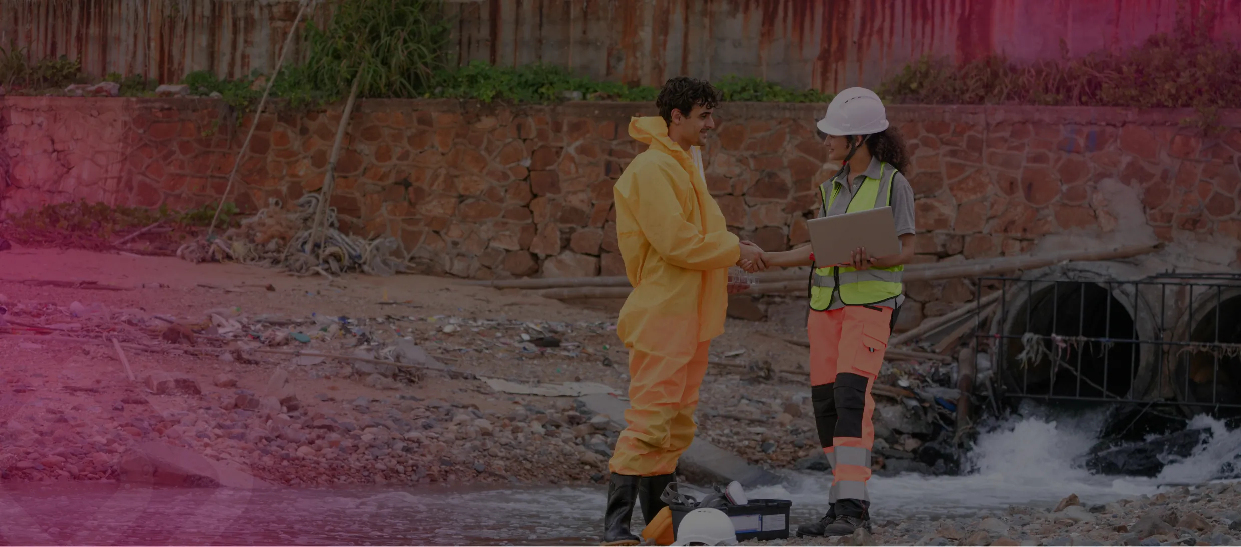 Two workers by a drainage culvert on a site