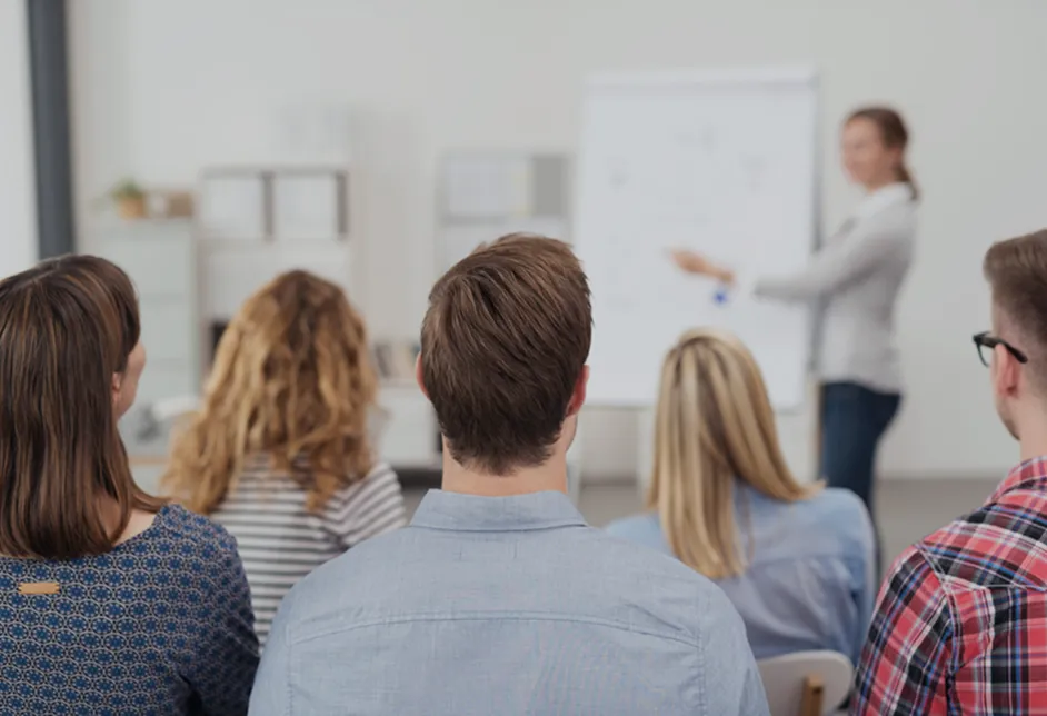 Team watching a colleague present at a whiteboard
