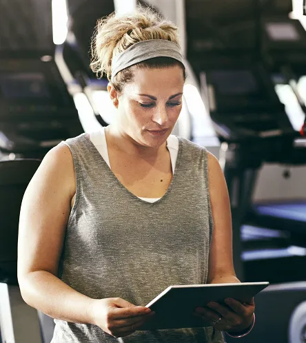 Woman using a tablet at a gym