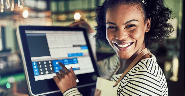 Smiling woman using a point-of-sale touchscreen