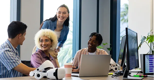 Team collaborating around a laptop in an office