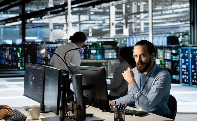 Man working at computers in a data centre