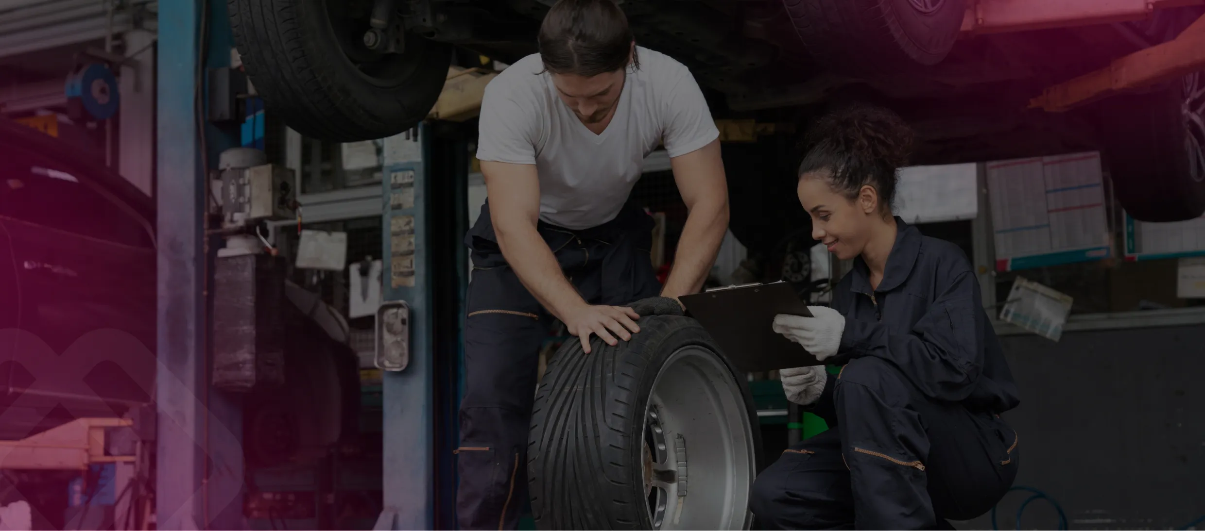 Two mechanics working on a car