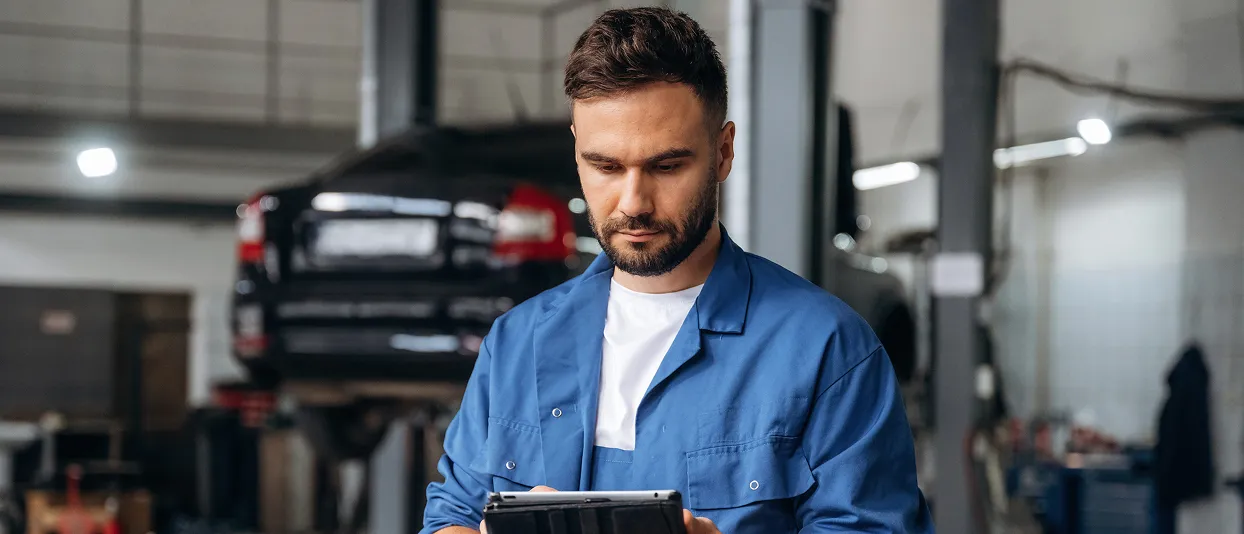Mechanic using a tablet in a workshop
