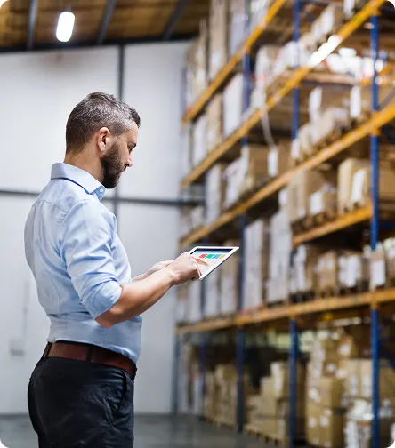 Man using a tablet in a warehouse aisle