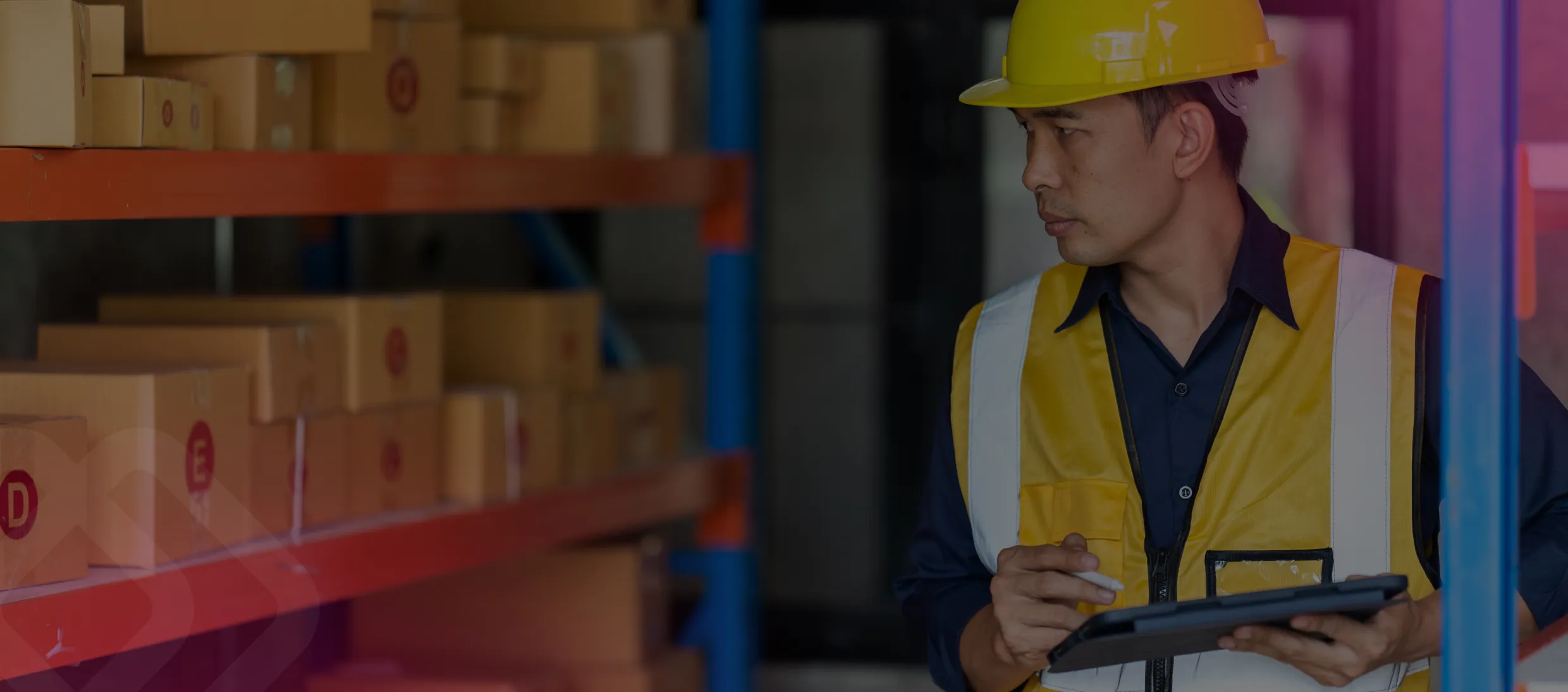 Worker in hi-vis using a tablet in a warehouse