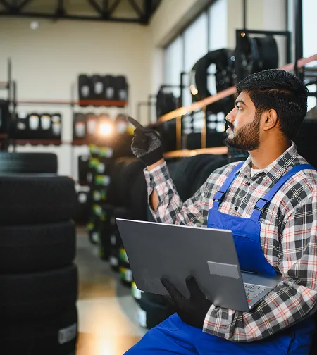 Worker using a laptop in a tire store